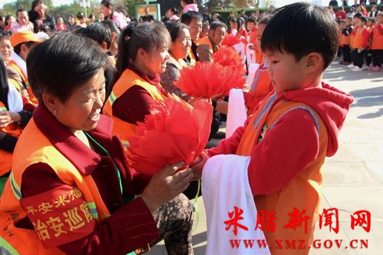 小博士幼儿园的小朋友们为环卫工奶奶献上大红花